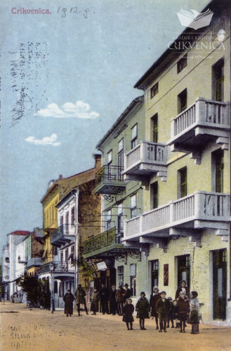 Razglednica u boji, prikazuje pročelja zgrada u glavnoj crikveničkoj ulici. Reprint.